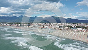 Aerial push towards the Appenine mountains of Tuscany towering behind the beautiful city of Viareggio