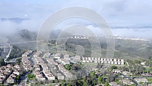 Aerial push view, morning fog over neighborhood of houses