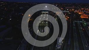 Aerial railway wagons at the railroad yard. View from the sky on railroad at night. The railway station aerial