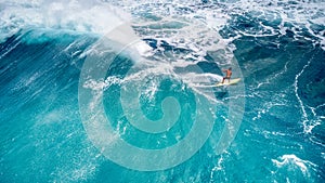 An Aerial Rear View of a Surfer Riding a Wave at Sunset Beach, Hawaii