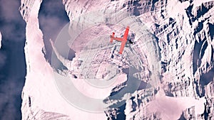 Aerial of red airplane flying over arctic snow landscape.