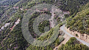 Aerial rising up to show road cut into side of mountain