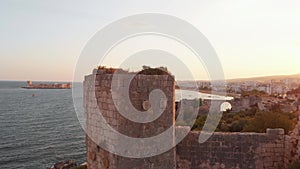 Aerial rising view Antik kiz kalesi fortification walls close-up in Kizkalesi turkish coast