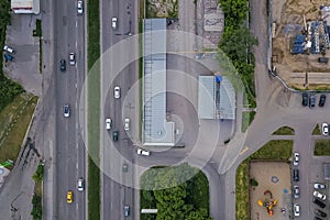 Aerial of road, car traffic and crosswalk with white stripes in the city among the green trees. Russian streets, Novosibirsk