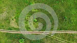 Aerial. Road through the rugged terrain. Green meadow. Top view