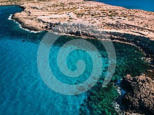 Aerial Rocky sea shore with crystal clear blue water, Cyprus, Blue Lagoon