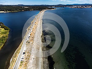 Aerial sand spit with a long straight road with cars parked in Victoria British Columbia Canada