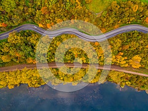 Aerial scenery view of winding road and railway beside in autumn fall
