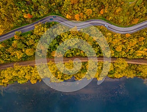 Aerial scenery view of winding road and railway beside in autumn fall