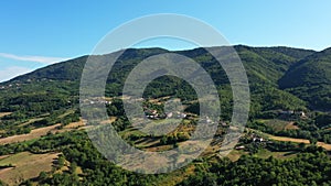 Aerial scenic panoramic landscape of the countryside. Houses stretch along the top of the mountain range. Traveling in Italy