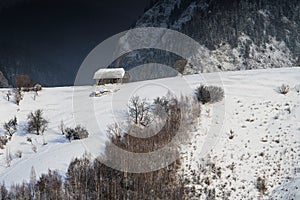 Aerial scenic rural view over Pestera village at the bottom of Piatra-Craiului Mountains during a freezing winter in Romania with