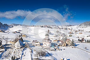 Aerial scenic rural view of the winter landscape from Fundata village in Romania at the bottom of Bucegi Mountains