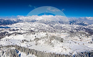 Aerial scenic rural view of the winter landscape from Fundata village in Romania at the bottom of Bucegi Mountains