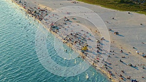 Aerial seascape with Siesta Key sandy beach in Sarasota, USA. Many tourists enjoying summer vacation time swimming in