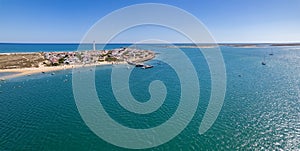 Aerial seascape view of Cape Santa Maria lighthouse island, Praia do Farol beach, one of the barrier islands that protect the Ria