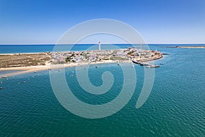 Aerial seascape view of Cape Santa Maria lighthouse island, Praia do Farol beach, one of the barrier islands that protect the Ria