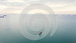 Aerial seascape view and small container ship floating in sea horizon and cloud sky background