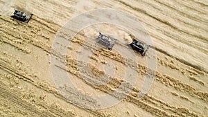 Aerial shot from above harvesters gathering crops from agricultural fields. Global food crisis and grain supply chains