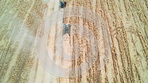 Aerial shot from above harvesters gathering crops from agricultural fields. Global food crisis and grain supply chains