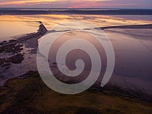 Aerial shot above Odessa Kuyalnik liman. A mud baths retreat clinic center in Ukraine, calm water sunset reflection