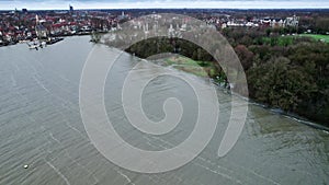 Aerial shot above waves of lake overflow the banks and flood the Park in city Hoorn harbor in the Netherlands