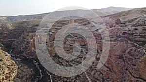 Aerial shot of the ancient Mar Saba Monastery built on rocky mountains and gorges