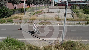 Aerial shot : Attractive Man rides his foldable electric bike on the street