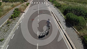 Aerial shot : Attractive Man rides his foldable electric bike on the street