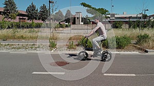 Aerial shot : Attractive Man rides his foldable electric bike on the street