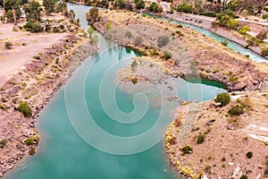 Aerial shot of an azure lake with a green small island in Provincia de Mendoza, Argentina