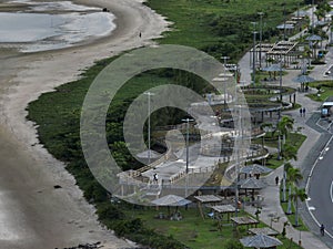 An aerial shot of a beach shore near the road