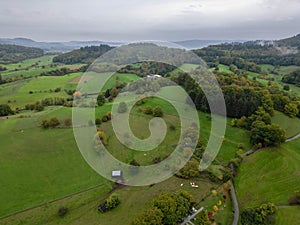 Aerial shot of a beautiful field with the green forest in the background in Odenwald Germany