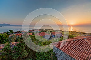Aerial shot of the beautiful houses by the ocean under the sunset captured in Lesbos, Greece