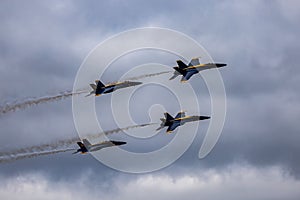 Aerial shot of the Blue Angels formation flying in the air against the gloomy clouds