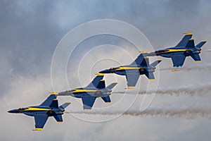 Aerial shot of the Blue Angels performing an air show before the clouds