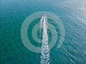 Aerial shot of boat crossing the ocean.