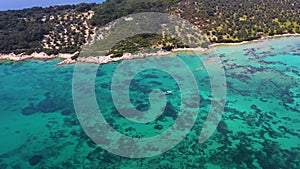 Aerial shot of the boat moving in the blue and clear waters of the Aegean Sea with a drone