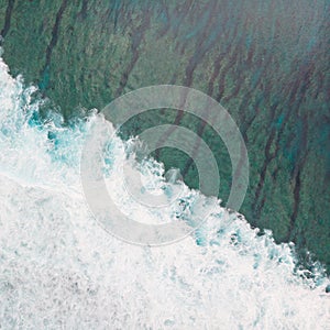 Aerial shot of the braking wave in the ocean.