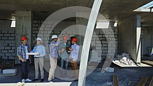 Aerial Shot Of Builders Team On Construction Site Discussing Plan Of Project With Architect And Contractor Using