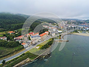 Aerial shot of building near the mountain under a cloudy sky in Galicia, Spain photo