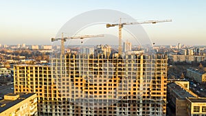 Aerial shot of the building in the process of construction. Labor working in big construction site. In the Background