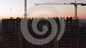 Aerial Shot of the Building in the Process of Construction. Labor working in big construction site. In the Background