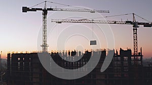 Aerial Shot of the Building in the Process of Construction. Labor working in big construction site. In the Background