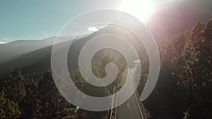 Aerial shot. Camera movement down. At sunset in the mountains. Winding mountain road - serpentine, Hairpin turn, Against