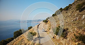 Aerial shot of a car following the beautiful coastline of Kefalonia island, Greece