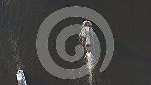 Aerial shot of cargo ship floats on the river or sea. Freight boat carriage goods. Drone fly over moves nautical vessel