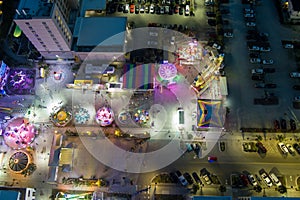 aerial shot of the Carolina Beach Boardwalk with ocean water, people on the beach, hotels and a Ferris wheel and carnival rides