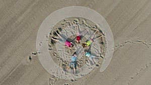 Aerial shot of children waving hands on the sand