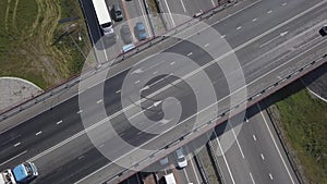 Aerial shot of city road traffic over big crossroad. Cars, buses and trucks driving by avenue. Vertical view.