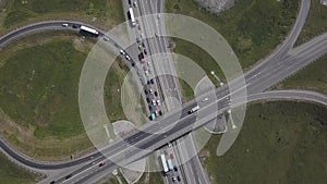 Aerial shot of city road traffic over big crossroad. Cars, buses and trucks driving by avenue. Vertical view.